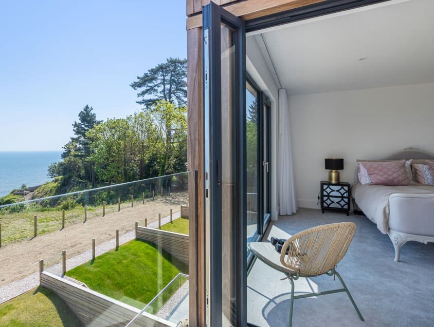 Bedroom opening onto a balcony with sea views